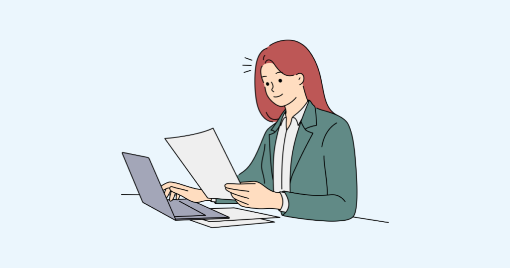 パソコンを操作しながら書類を見る女性